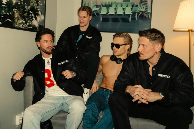 Pressbild på musikgruppen De Vet Du. 4 män sitter i en soffa.